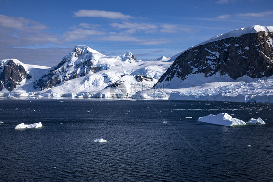 正面水在蓝海前有冰雪的山峰南极洲也有大片冰块分层的图片