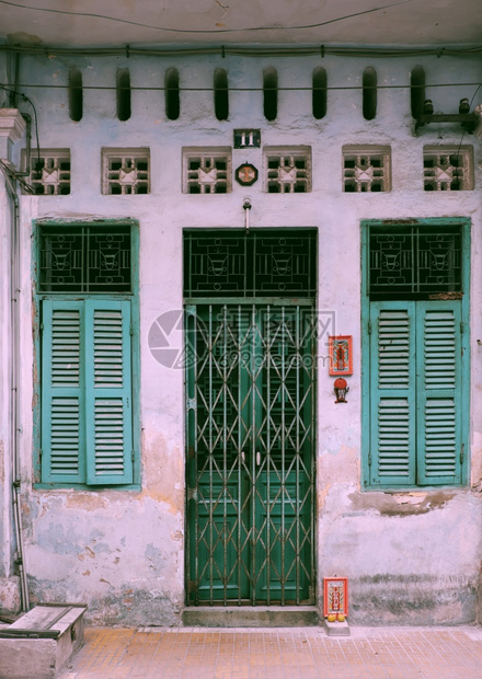 亚洲人典型的西贡在越南胡志明市华人城镇的房屋典型风格以观视前方的风景令人惊叹的古老外表其形态是时间颜色旧木门和铁后绿窗图片