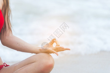 在海滩上的瑜伽健身生活方式康女放松做冥想瑜伽模拟室外和zen坐着的姿势启蒙运动年轻快乐浓缩运动概念爱抚阳光幸福手指图片