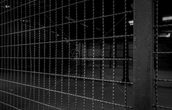 光栅私人地区黑暗背景钢围栏安全墙仓库建筑内门网状围墙自由概念障碍铁栅和电杆的链条铁栅栏和电线杆的链条倒钩工业图片