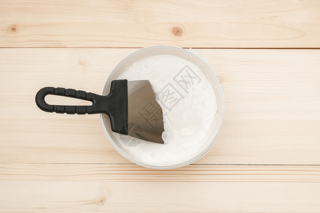装修刨丝器刮刀木板上的抹和一桶白色腻子顶视图复制空间抹刀和木板上的一桶白色腻子图片
