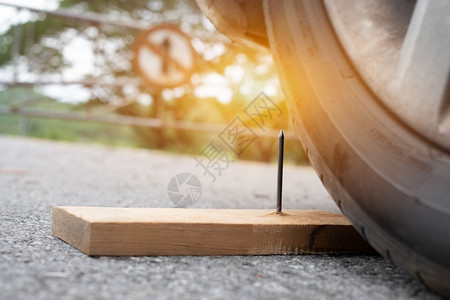 事故插头把木板上的铁钉紧贴在木头上几乎穿入轮胎按钮图片