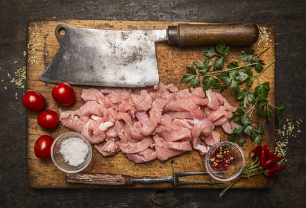 新鲜的健康食物烹饪火鸡肉刀面叉盐在生锈木本底顶视图的制切割板上食用成分图片