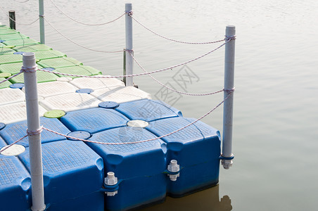 系船柱长着绳子栅栏的塑料浮在城市公园的小湖上自然浮桥图片