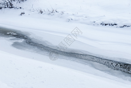 细节户外接触在有雪和冰的河开放水域图片