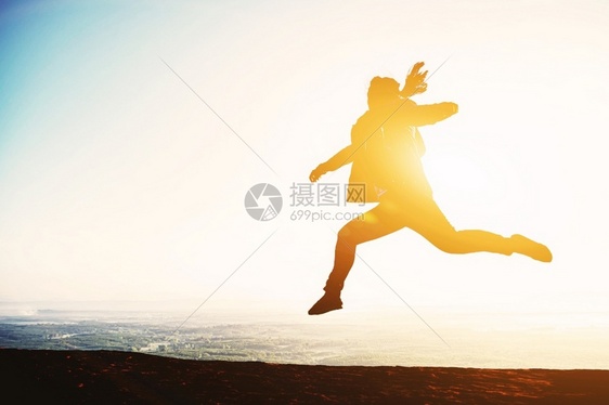 女愉快月光青年在日落背景下跳跃生活图片
