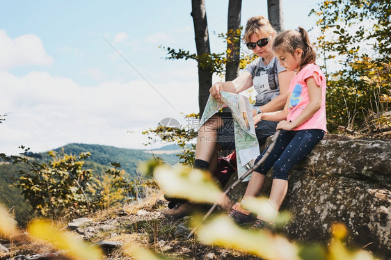 母亲和女儿在山上探亲出考察山区试验在山上度假的暑期中坐在岩石上享受夏日的山地上进行试验外部女孩人们图片