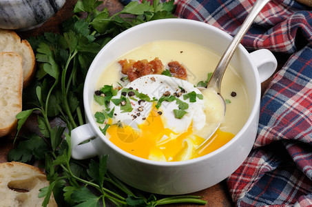 勺子配有培根和偷鸡蛋草药香料的大蒜土豆奶油汤餐巾胡椒图片