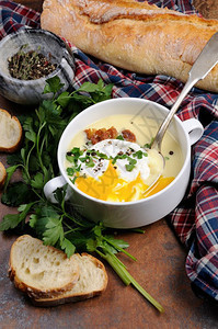 配有培根和偷鸡蛋草药香料的大蒜土豆奶油汤营养的蛋黄菜肴图片