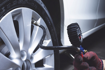 汽车修理工检查轮胎店的压力空气车乐器图片