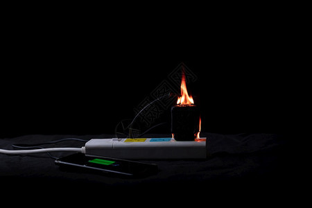 连接燃烧的着火在充电时使用移动话源适配器烧火图片