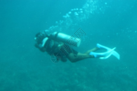 活动面具生潜水员穿着面罩脚蹼和氧气球在海水中潜员在下游泳气泡从潜水员氧面罩中出现在水下游泳图片