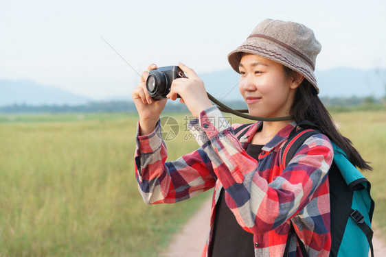 天空热带自由一位年轻女孩在暑假旅行大自然山观上用数码相机拍摄照片的亚洲旅游女客图片