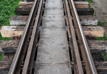 旧铁路线和金属板使旅行者在铁轨上的旧路桥行走黑色的基础设施自然图片