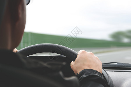 里面男在汽车方向盘上紧贴男手在公路模糊的背景下降低音调效果成人旅行图片