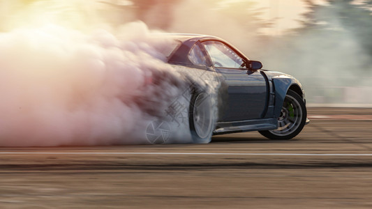 车轮引擎汽漂流模糊的图像扩散闪亮的图像传播种族游车与大量烟雾一起在高速轨道上燃烧轮胎赛车图片