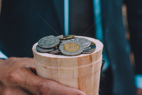 手持硬币和木桌纸堆叠的硬商业融资概念市场收入管理图片