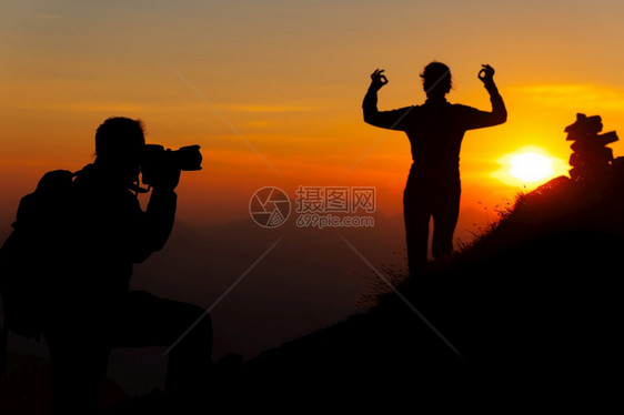 冒险景观山上摄影师是一个女孩日落瑜伽姿势在光影中服用图片