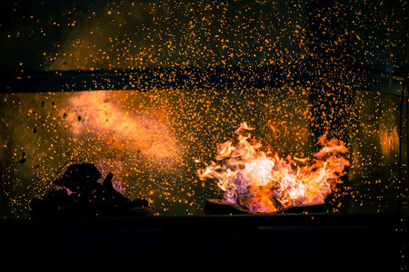 黄色的黑暗在抽象背景下燃烧木炭的火焰和花与bokeh粒子图片