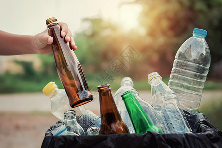 采摘将垃圾瓶玻璃装进回收袋用于清洁安装在回收袋中重用人们图片