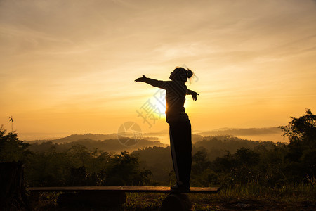泰国请享用在山峰日出时自由欢呼的女士张开双臂黑色的图片