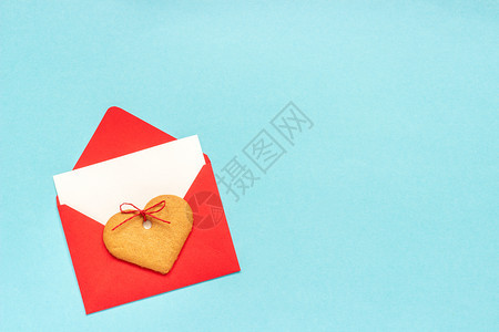 惊喜庆典象征红信封空白纸卡用于文字和心形姜饼干放在蓝背景上翻版空间错装用爱的红信封打喜悦黑白纸卡放在蓝背景上图片
