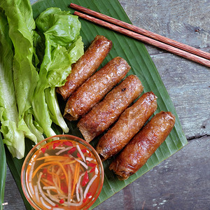 咸味的越南食物春卷或千焦一种美味的油炸食品气瓶形状用面包沙拉和鱼酱吃这也包括丰富的卡路里胆固醇脂肪食品受欢迎的越南饮食课程语图片