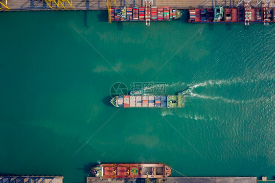 海港拖船将集装箱通过起重机推向码头以装载集箱用于物流进口出航运或输的空顶端视角货图片