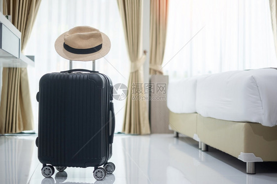 奢华现代旅馆房间的黑色行李和帽子有窗户帘和床铺旅行放松和休假概念的时间预订气泡图片