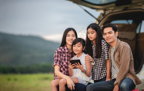 快乐的小女孩有亚裔家庭坐在车里享受公路旅行和夏假在野营车面包上坐着美丽的假期图片