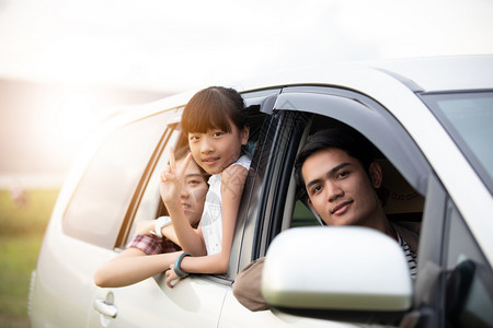 美丽的快乐小女孩有亚裔家庭坐在车里享受公路旅行和夏假在野营车面包上年轻的冒险图片