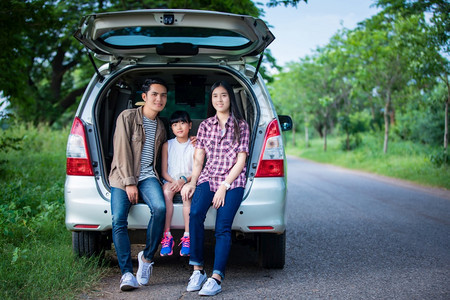 快乐的小女孩有亚裔家庭坐在车里享受公路旅行和夏假在野营车面包上汽母亲父图片