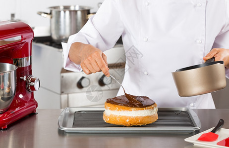 美味的糖霜厨房糕点师装饰巧克力蛋糕手图片