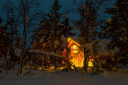 木屋深夜寒冬森林分支底有大顶雪亮小屋盖覆在夜间白雪森林和木岩层中分支机构舱图片