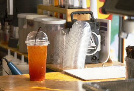 在街上迷你咖啡店的木柜台上塑料杯中的冰柠檬茶贴近了杯子餐厅寒冷的图片
