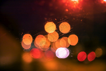 本市夜间玻璃窗上下雨滴抽象bokeh模糊背景重点黑色的粉图片