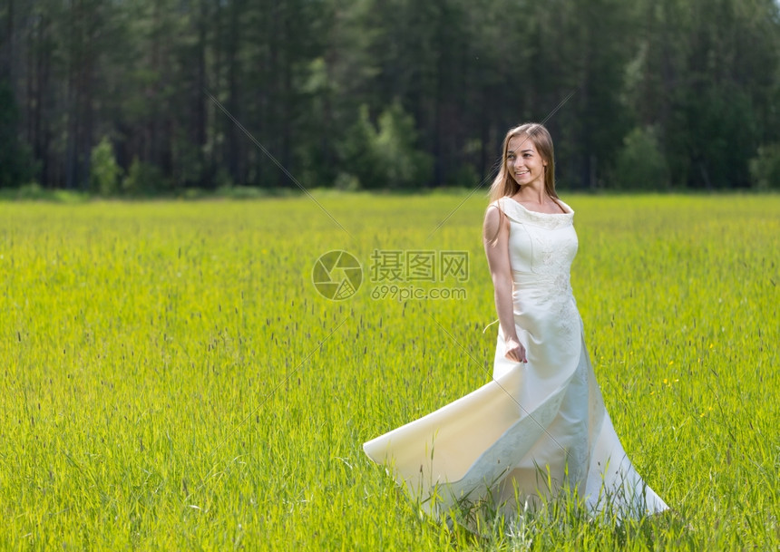 手景观喜悦身着白衣服的年轻微笑女子站在田里图片