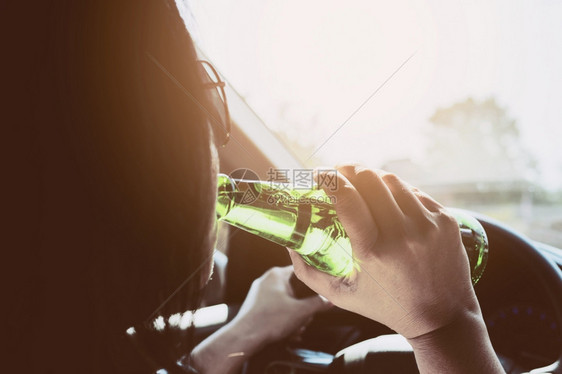 男抓住妇女开车时喝酒啤交通图片
