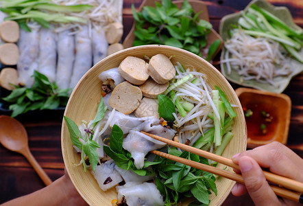 黄瓜美味的高最顶端观众与越南素食者一起吃早餐的越南人滚炒米饭煎饼或用香草和酱汁放在家木桌上图片