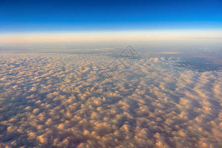 金的在日出交通和旅行者构想时从飞机侧窗对面的视线上向外倾望天空的金云多于运输图片
