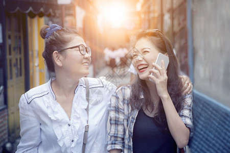 旅行生活在购物街上两个亚洲女人近地面露着笑容的和欢乐情绪放松图片