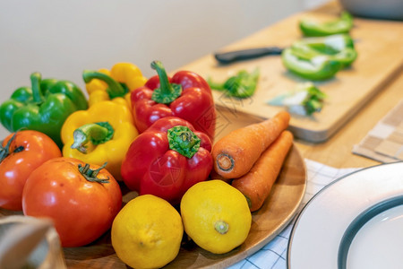 女酒吧木板原始沙拉食品准备做厨师烹饪在现代厨房饮食和健康物概念中配有番茄柠檬胡萝卜和椒图片