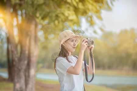 亚洲人放松妇女摄影机旅行和拍照自然美丽图片