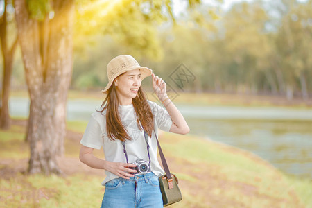 微笑享受秋天亚洲妇女摄影机旅行和拍照自然图片