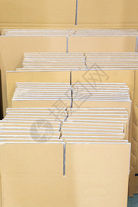 装填教育书的纸板堆在仓库墙附近铺设了纤维素黄色的床单图片