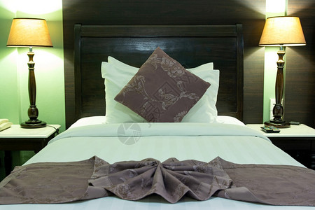 床头睡觉铺有枕和桌灯的床间内衣木头图片