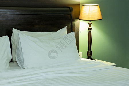 铺有枕头和桌灯的床间内衣羽绒被电的房间图片