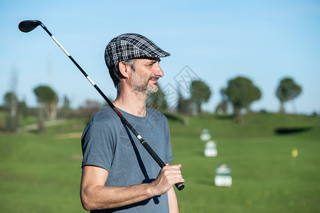 高尔夫球员的帽子和俱乐部在他的肩上一个驾驶课程外部高尔夫球手日落图片