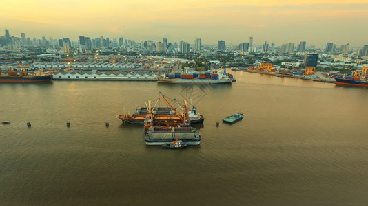 天线血管由Klongtuey港口和集装箱船在Chaopraraya河中心Bangkokthailand首府上空装载稻田的水角度图片