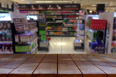 走道空木板桌间平台和模糊的超市过道产品展出时有架背景显示设备手推车大卖场图片